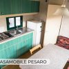 Cucina compatta con fornelli e frigorifero.