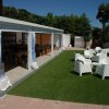 Veranda con tavoli e sedie su prato verde.