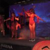 Persone in costume su un palco con sfondo blu.