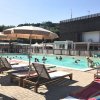 Piscina con lettini e ombrelloni beige.