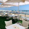 Tavoli con ombrelloni in riva al mare.