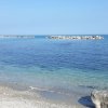 Mare calmo con scogli in lontananza.