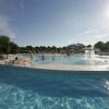 Piscina all'aperto con fontana e persone che nuotano.