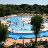 Piscina con molte persone e ombrelloni.