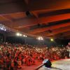 Esibizione sul palco con folla spettatrice.