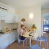 Interno moderno di una cucina con madre e due bambini che fanno colazione.