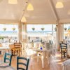 Ristorante vista mare con tavoli apparecchiati.
