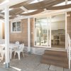 Terrazza con tavolo e sedie di plastica bianca.