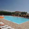 Piscina all'aperto con lettini e ombrelloni colorati.