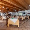 Una sala ristorante spaziosa con tavoli apparecchiati e soffitto in legno.