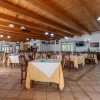 Un ristorante spazioso con tavoli apparecchiati e soffitto in legno.