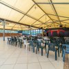Ampia sala con sedie di plastica rivolte verso un palco.