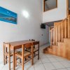 Sala da pranzo con tavolo e quattro sedie vicino a una scala in legno.