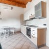 Cucina moderna con forno, piano cottura, tavolo e sedie.