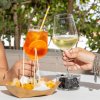 Due persone brindano con aperitivi e stuzzichini.