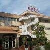 Facciata di un hotel club con piante e insegna.