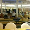 Ristorante con tavoli apparecchiati e un cameriere al centro.