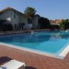 Piscina all'aperto circondata da lettini, vicino a edifici residenziali.