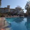 Piscina all'aperto con lettini, hotel sullo sfondo.