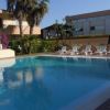 Piscina con lettini vuoti, circondata da palme.