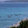 Spiaggia con mare calmo e bagnanti, vista dall'alto.
