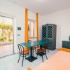 Stanza con tavolo, sedie e porta che si apre su un giardino.