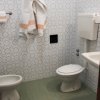 Bagno con piastrelle decorate e sanitari bianchi.