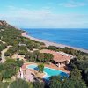 Complesso con piscina vicino alla costa e colline.