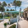 Terrazza all'aperto con sedie in rattan, vicino a un giardino alberato.