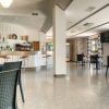 Interno di un bar moderno con tavoli, sedie e bancone ben fornito.