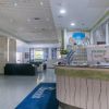 Una hall d'hotel con banco della reception e area salotto.