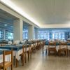 Sala da pranzo con tavoli apparecchiati e finestre ampie.