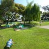 Giardino con tavoli e sedie sparsi su un prato verdeggiante.