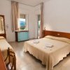 Camera d'albergo con letto matrimoniale e singolo, mobili in legno e finestra.
