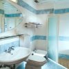 Bagno moderno con doccia, lavabo e piastrelle bianche e azzurre.