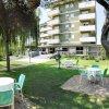 Tavolini e sedie in giardino davanti a un edificio a più piani.