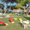 Area giochi per bambini con scivoli e tavolini su prato.