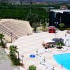 Un anfiteatro all'aperto con sedute, vicino a una piscina e diverse aree relax.