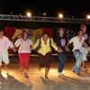 Un gruppo di persone che ballano insieme su un palco con luci accese.