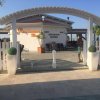 Ingresso di un bar-ristorante sul mare con veranda bianca.