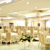 Sala da pranzo elegante con tavoli rotondi, sedie imbottite e lampadari.