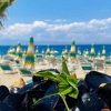 Dei mitili con pane e basilico in primo piano; sullo sfondo, ombrelloni in spiaggia.