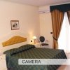 Una camera da letto elegante con letto matrimoniale, comodini con lampade e tende dorate.