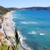Vista panoramica di una costa con mare blu e spiagge sabbiose.
