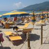 Spiaggia con lettini e ombrelloni gialli.