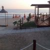 Spiaggia al tramonto con ombrelloni chiusi.