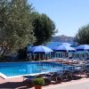 Piscina con lettini blu e ombrelloni, vista mare.