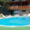 Piscina rotonda con ombrelloni e scivolo.