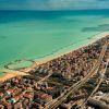 Vista aerea di una costa con città e litorale.