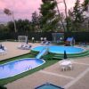Piscina con sdraio, ombrelloni e scivolo.